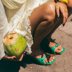 green heels for women styled for summer vacation outfit with coconut drink