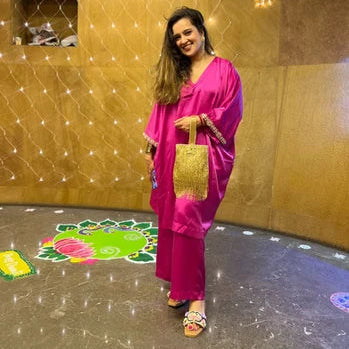 Woman in a bright pink traditional outfit and wearing Gulraj floral jute sandals.