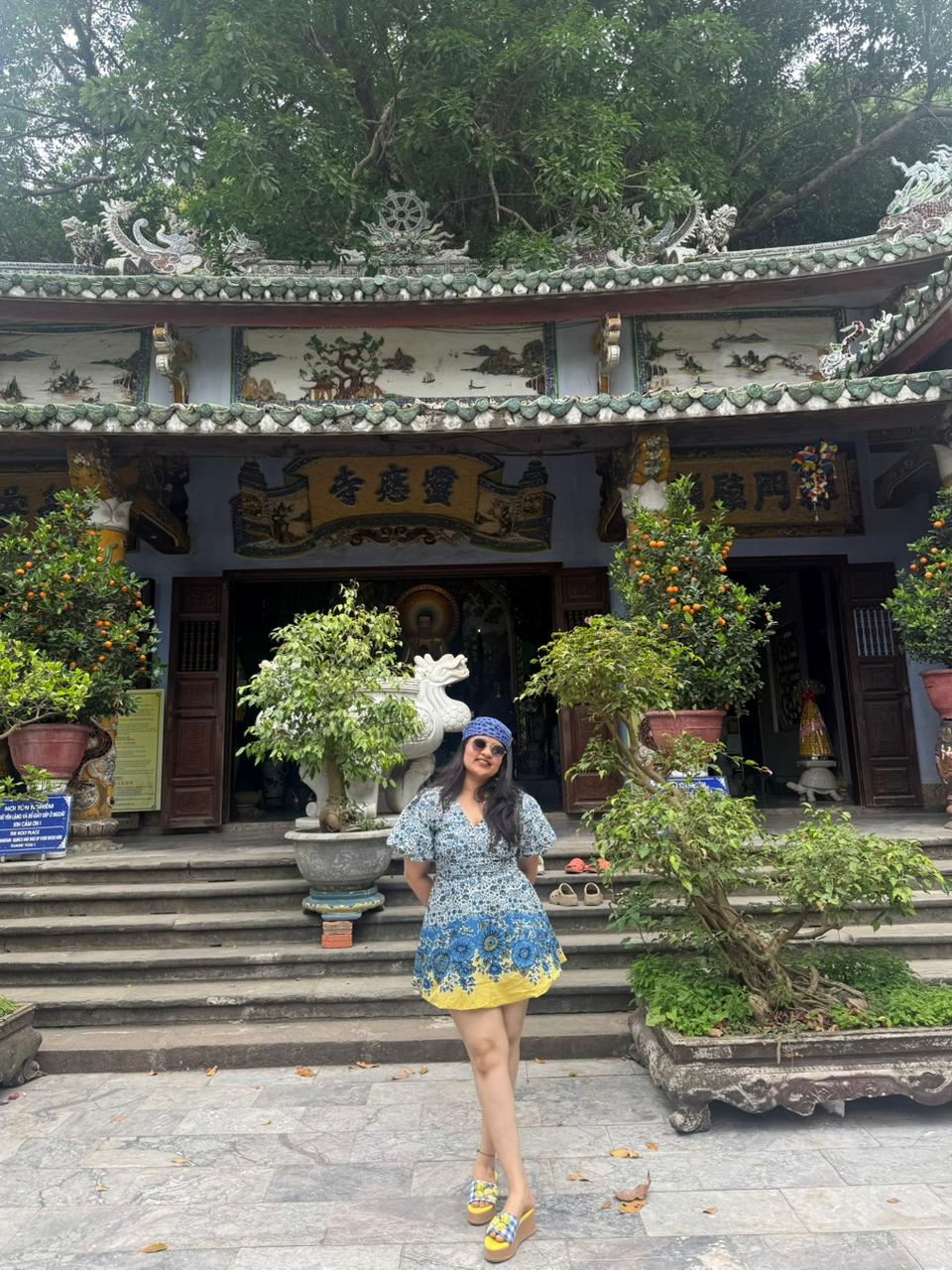 Customer wearing Limoncello slides on a vacation paired with a stunning yellow and blue midi dress in Vietnam 