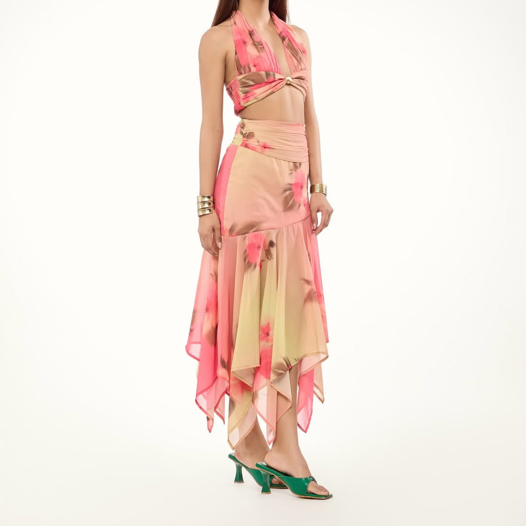 Woman wearing a pink and beige outfit with green shoes on a white background